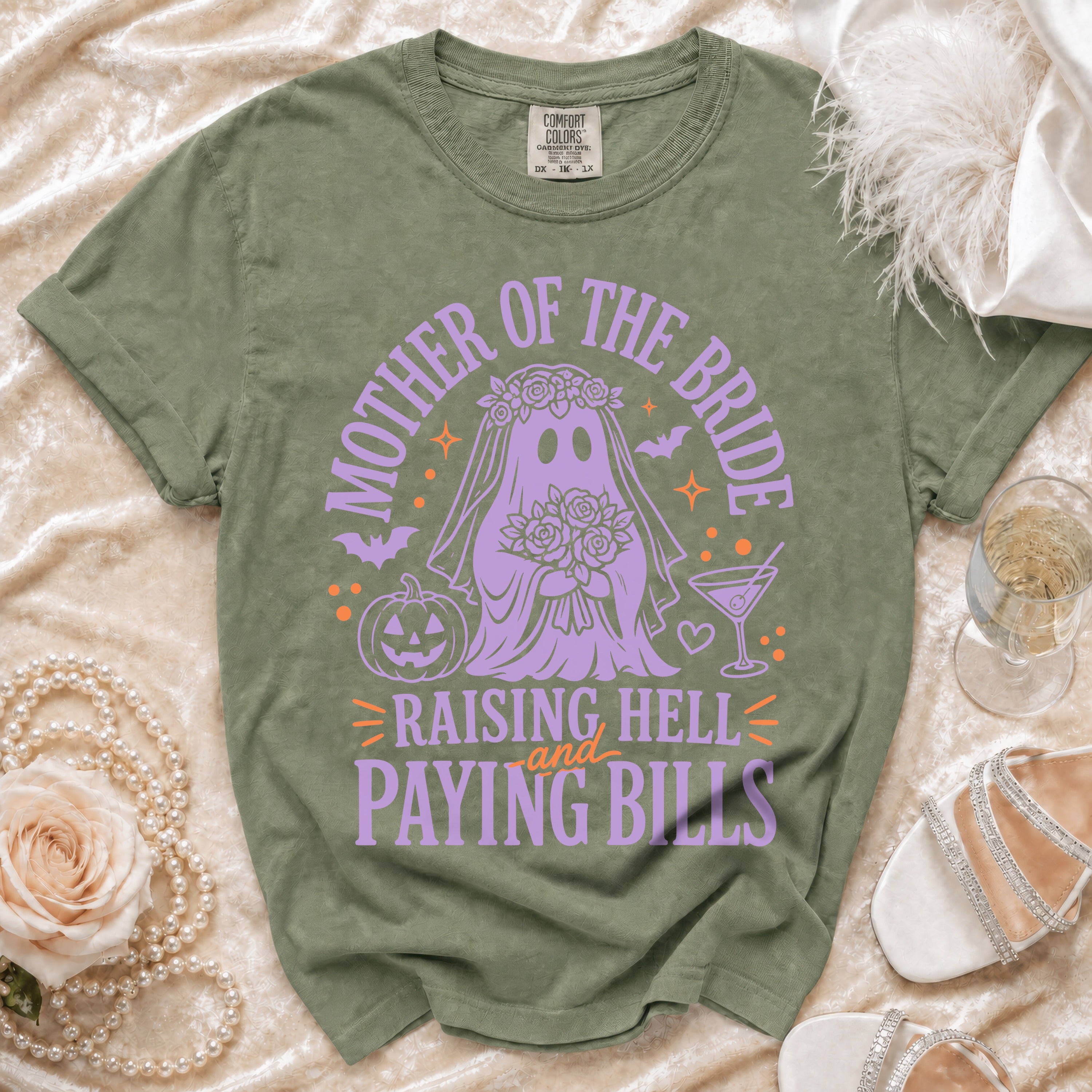 Olive green t-shirt with purple ghost bride graphic and text: "Mother of the Bride Raising Hell and Paying Bills."