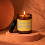 Amber glass candle lit, with "Forever Smells Like This" text on yellow label.