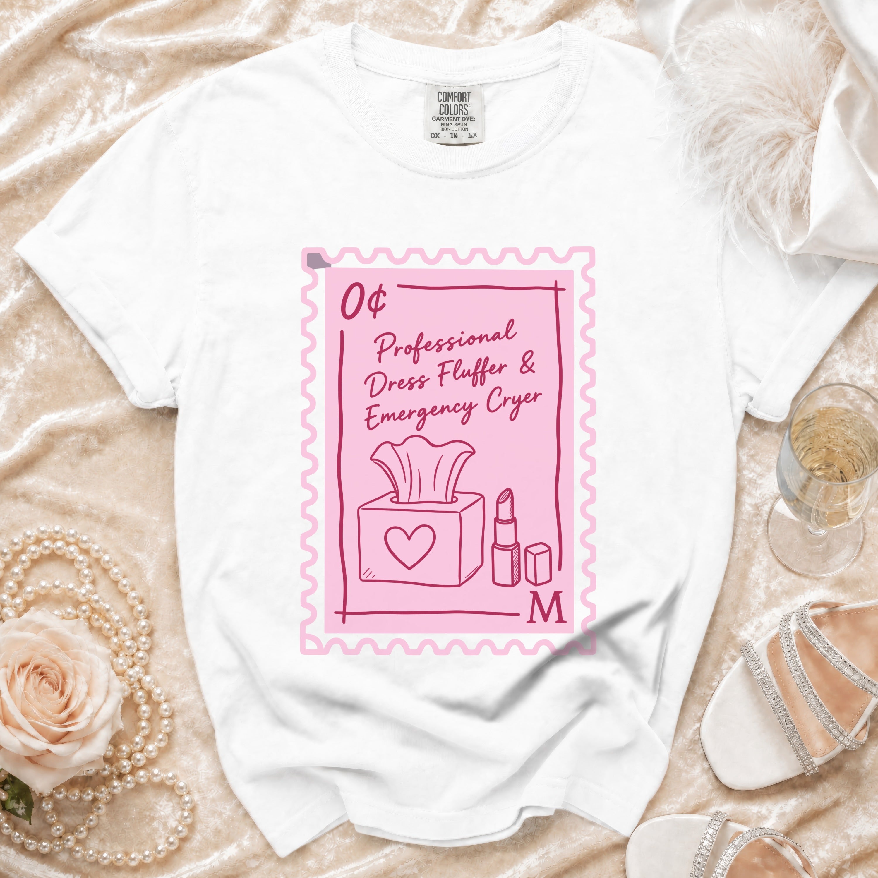 White t-shirt with pink stamp graphic: Professional Dress Fluffer & Emergency Cryer.