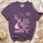 Purple t-shirt with "Lucky" graphic, ghost bride, and romantic spooky text.