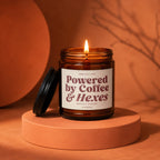 Amber jar candle with label "Powered by Coffee & Hexes".