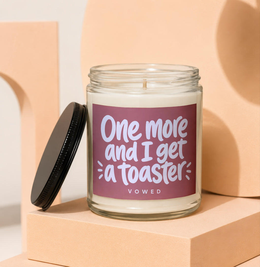Glass candle with burgundy label that reads "One more and I get a toaster VOWED".