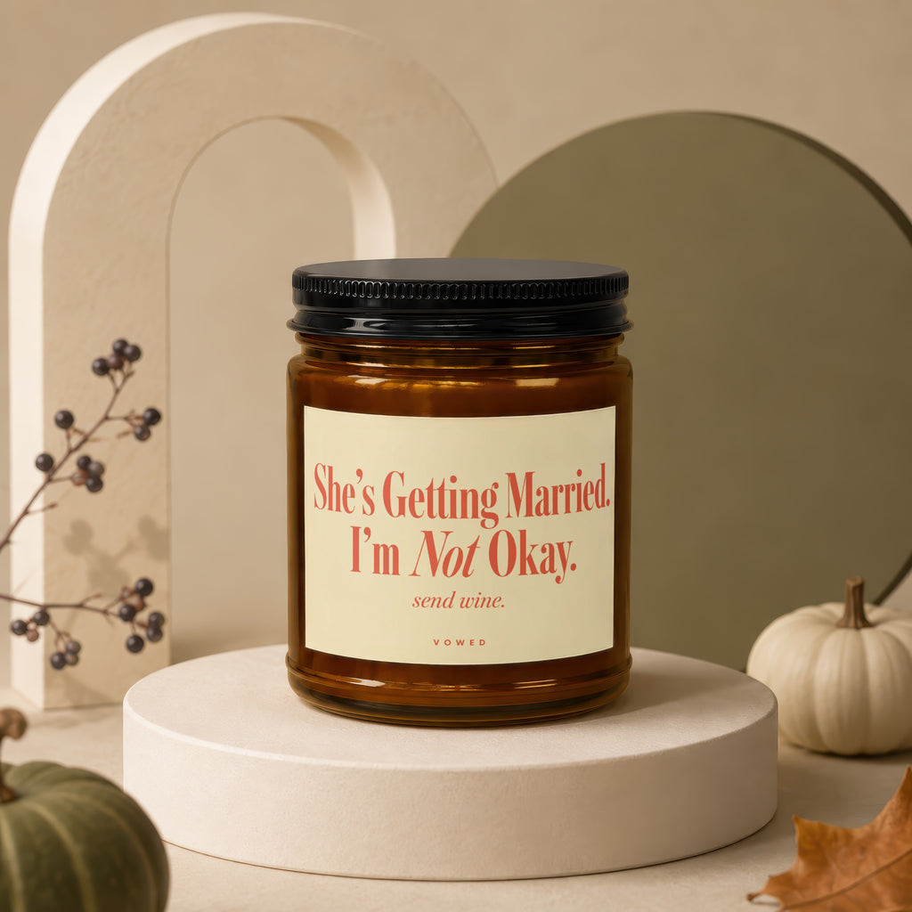 Amber candle with "She's Getting Married. I'm Not Okay. send wine." text on label.