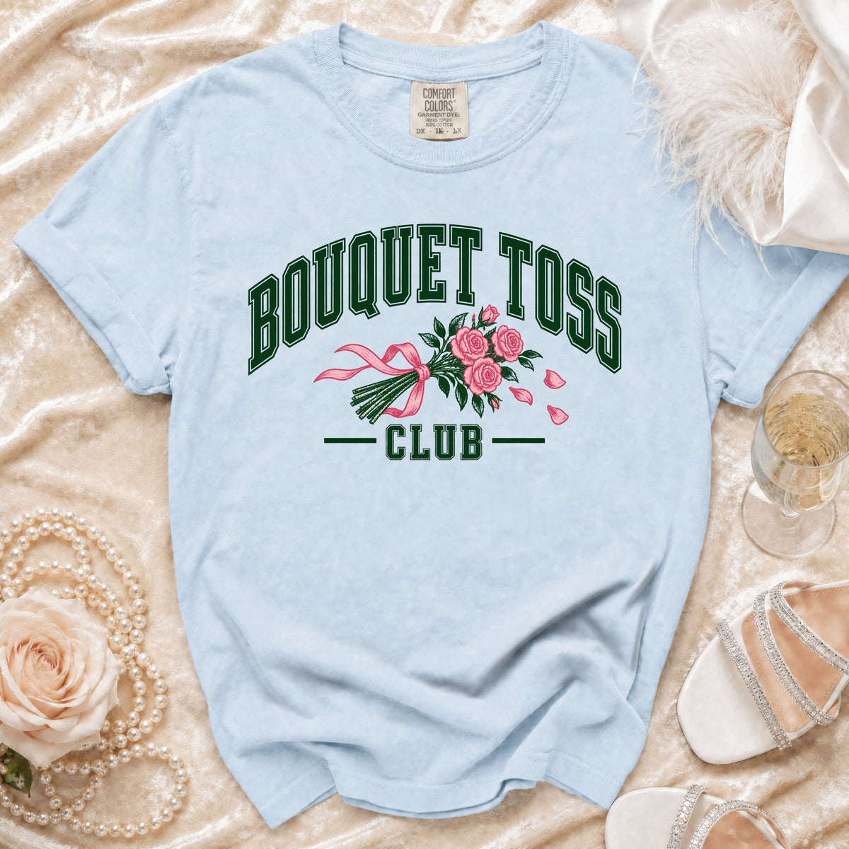 Light blue t-shirt with "BOUQUET TOSS CLUB" text and a pink bouquet graphic.