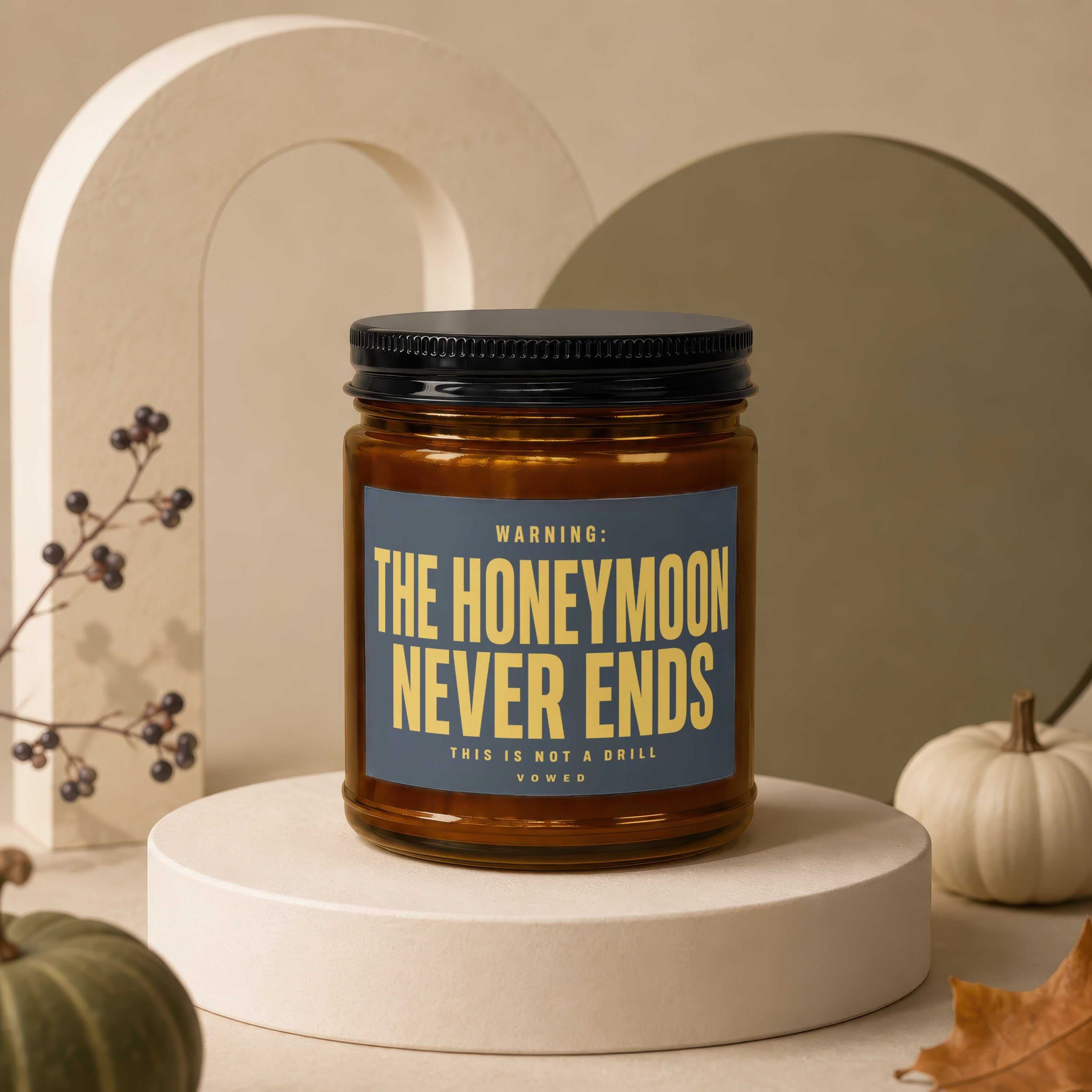 Amber jar candle with black lid, text reads: THE HONEYMOON NEVER ENDS, THIS IS NOT A DRILL, VOWED.