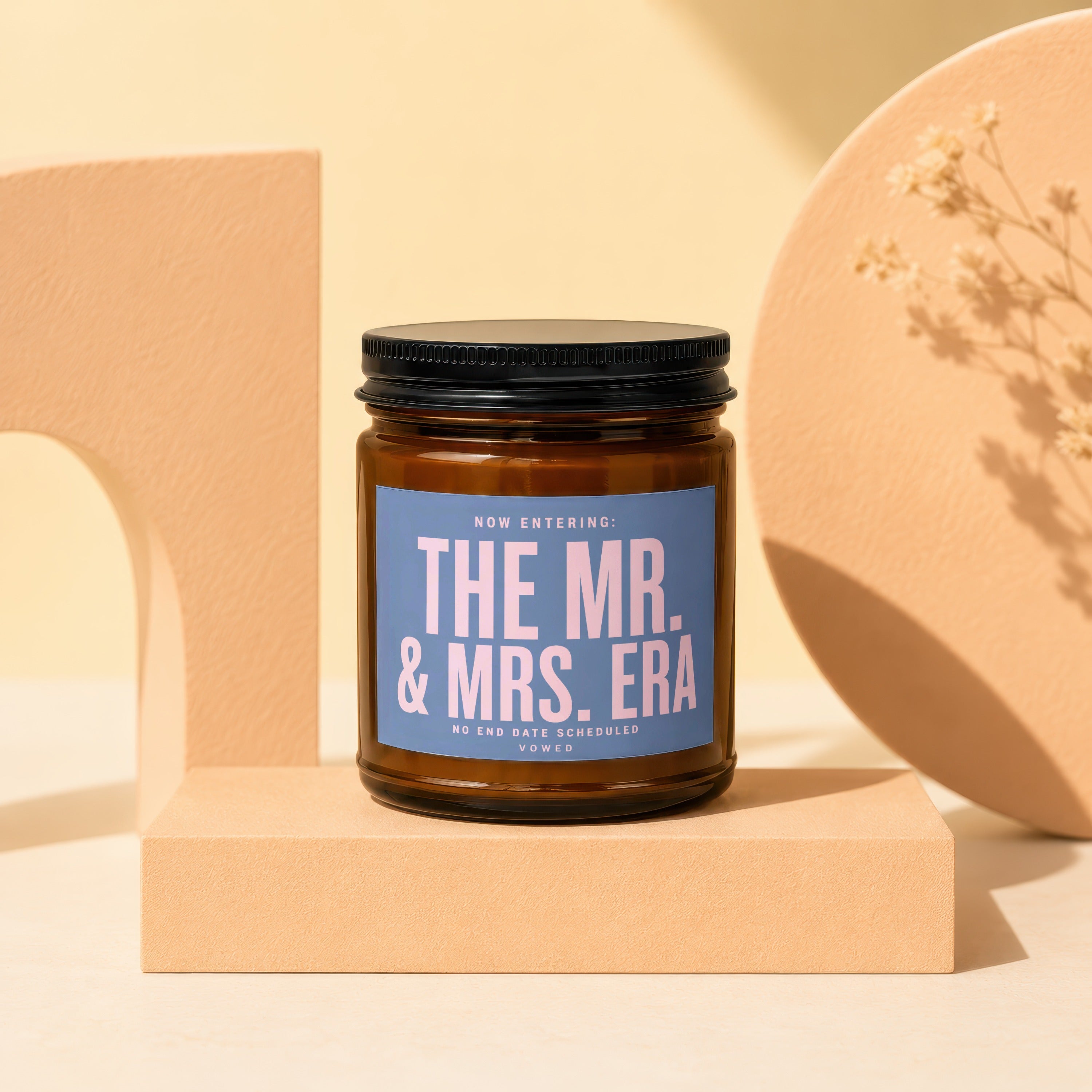 Amber candle with a blue label reading "THE MR. & MRS. ERA".