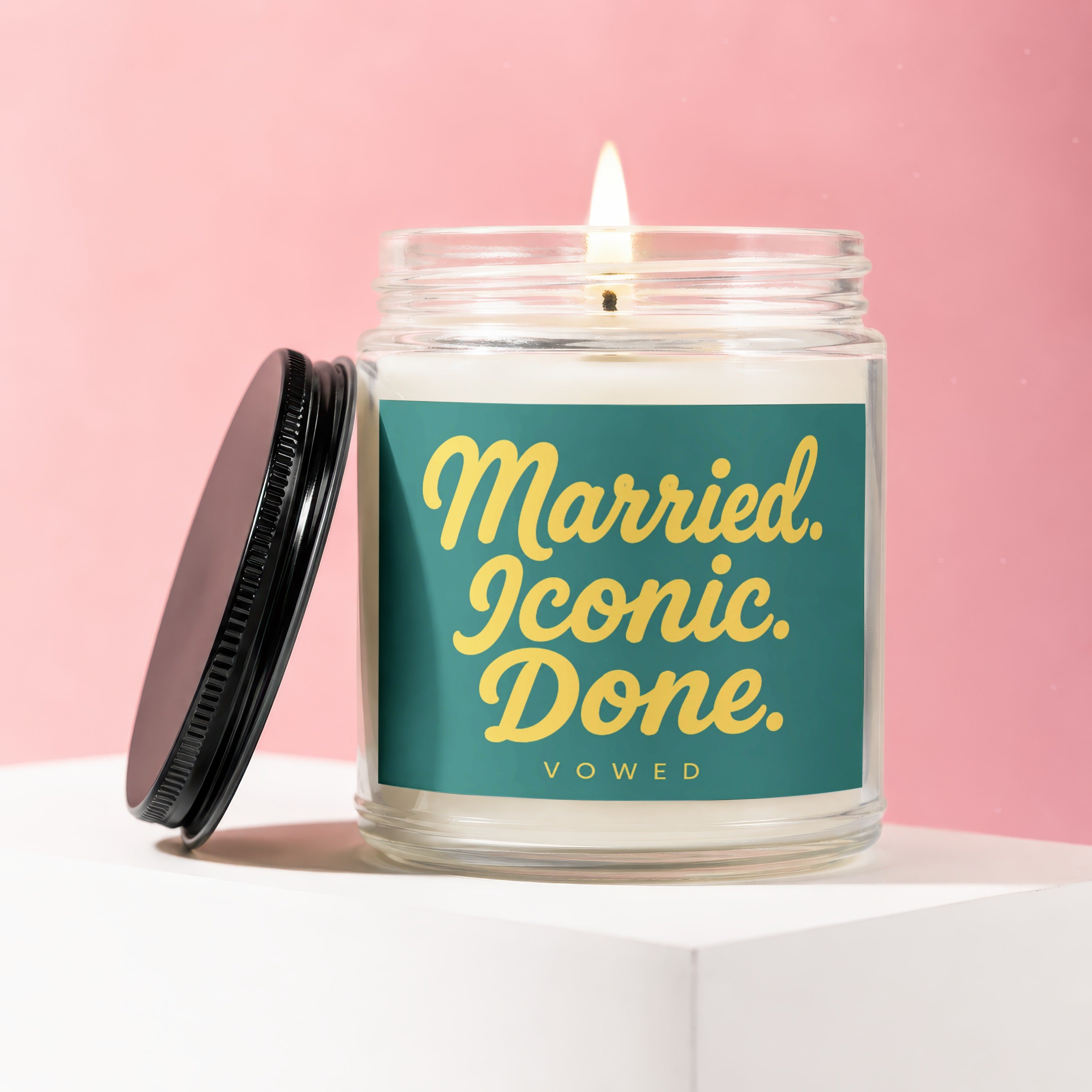 Candle with black lid titled "Married. Iconic. Done. VOWED." on teal label.