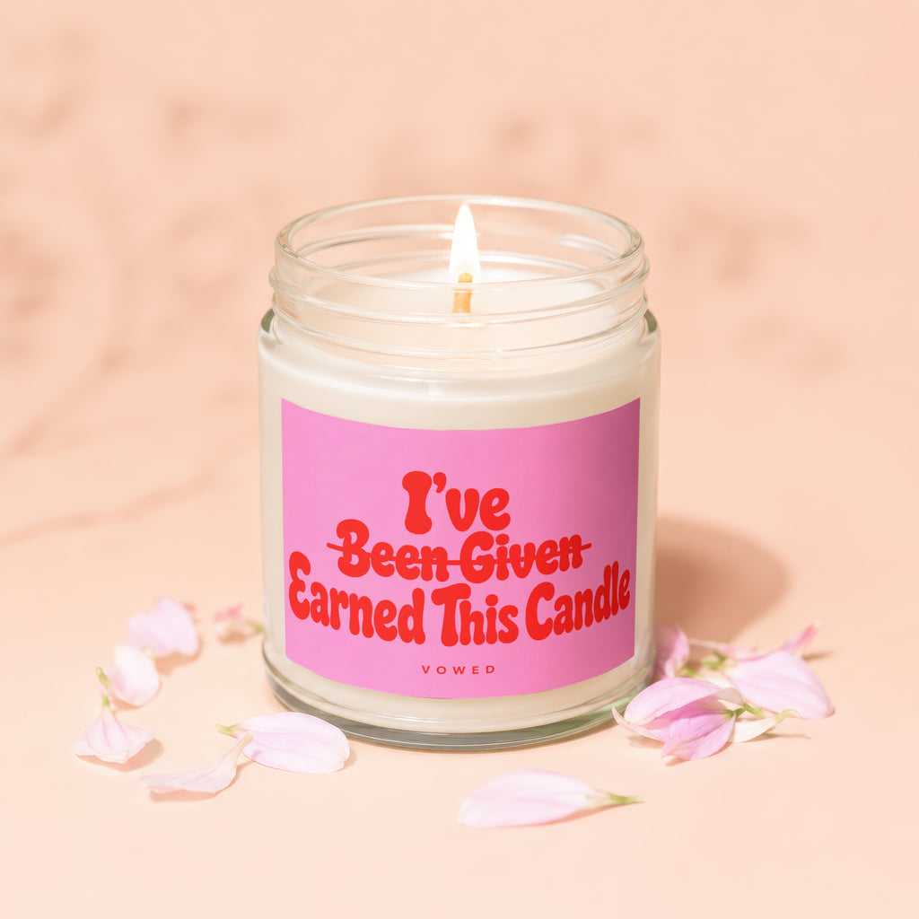 Glass jar candle with pink label reading "I've Earned This Candle"