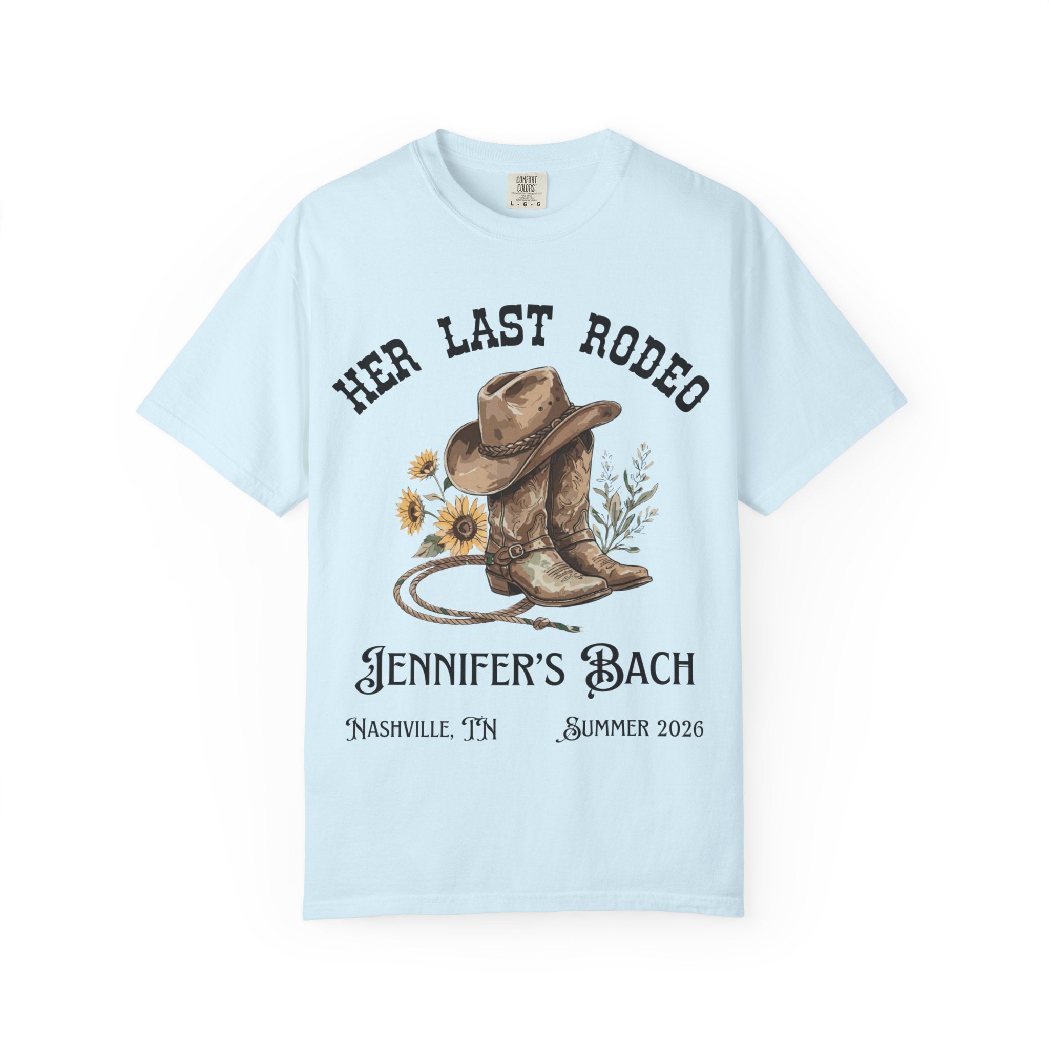 Light blue t-shirt with cowboy boots, hat, and lasso graphic for Jennifer's Bach Nashville Summer 2026.