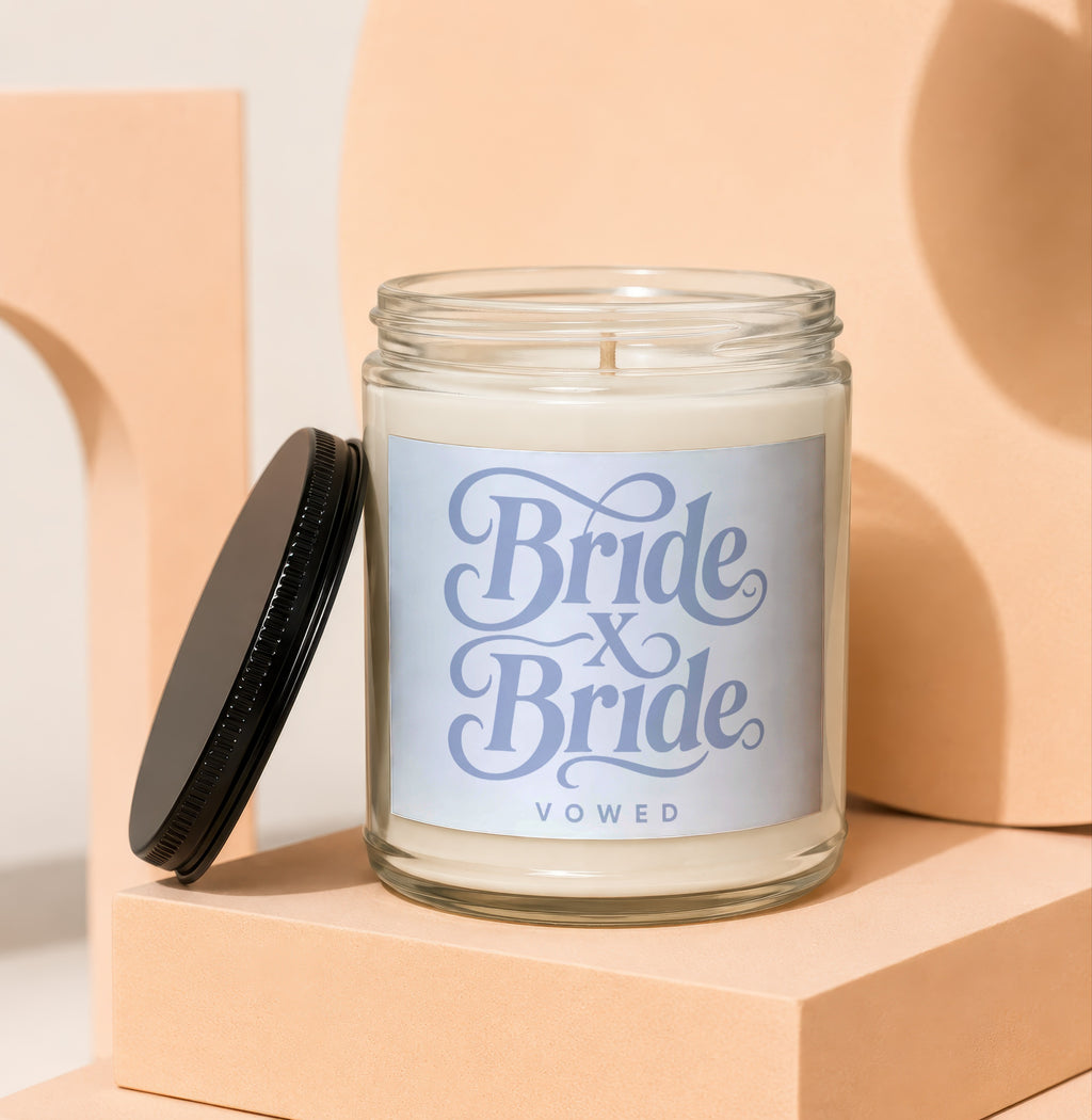 Glass candle with "Bride x Bride Vowed" text on a light blue label.