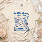 T-shirt with "Reckless in Texas Olivia's Bach Austin, TX Summer 2026" and Western graphics.