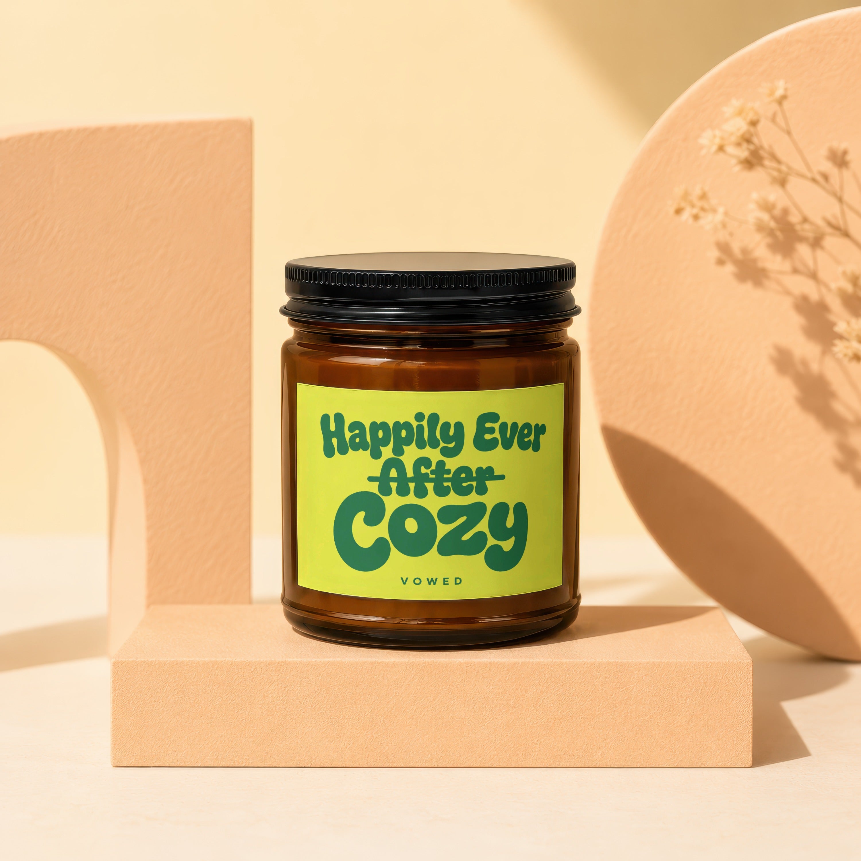 Amber jar candle with "Happily Ever After Cozy Vowed" text on a lime green label.