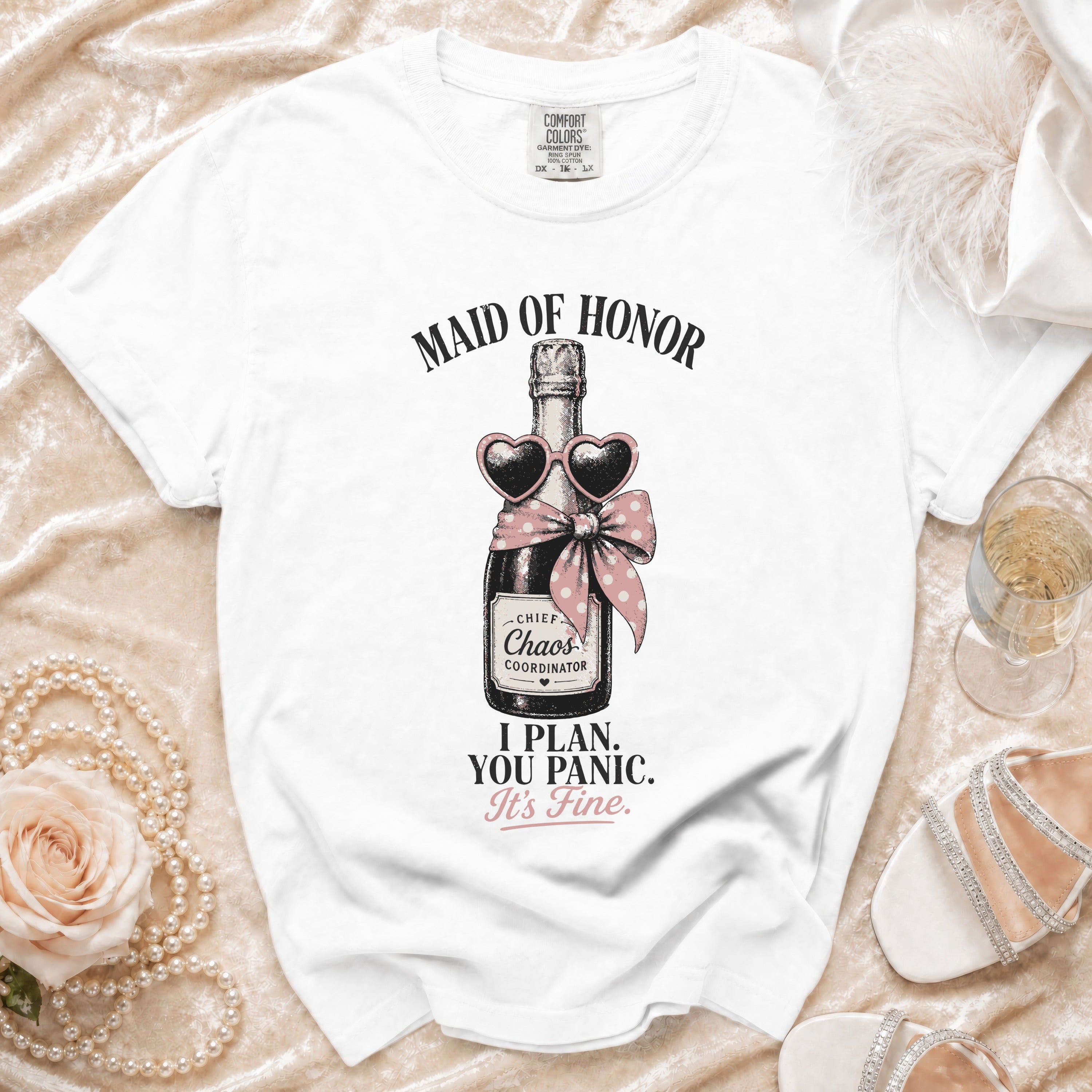 White t-shirt with "Maid of Honor" and a champagne bottle graphic with text.