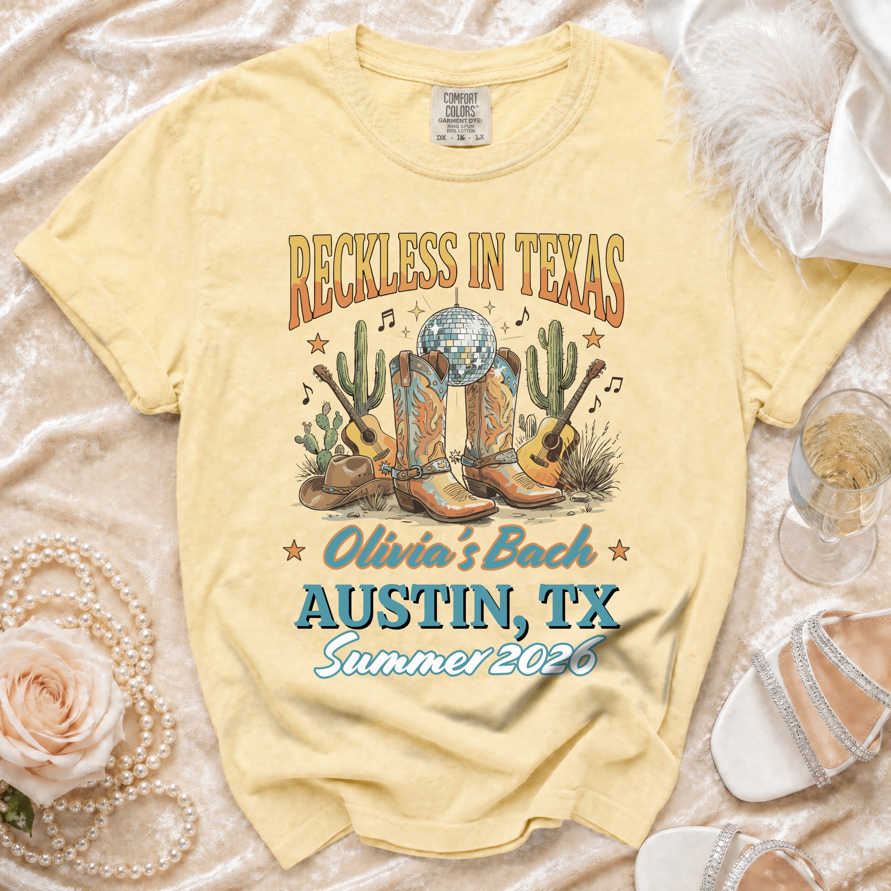 Yellow t-shirt with "Reckless in Texas Olivia's Bach Austin, TX Summer 2026" graphic.