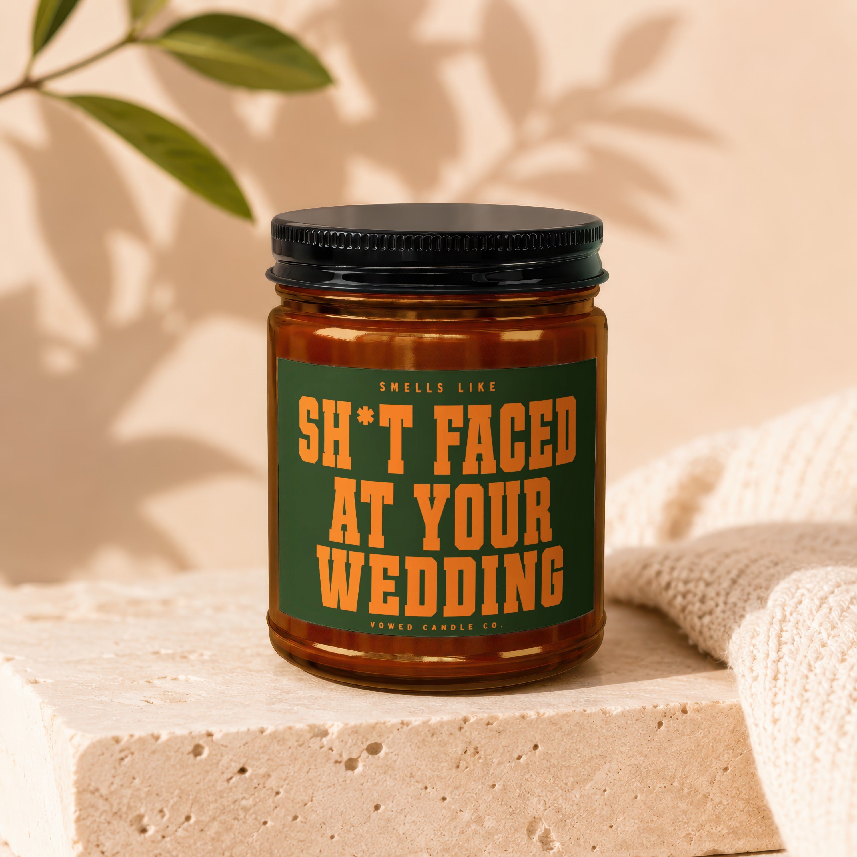 Amber candle with black lid, label reads "Smells Like Sh*t Faced At Your Wedding".