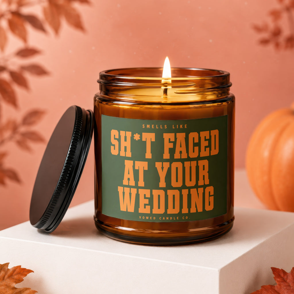 Amber jar candle with "Sh*t Faced At Your Wedding" text, lid off.
