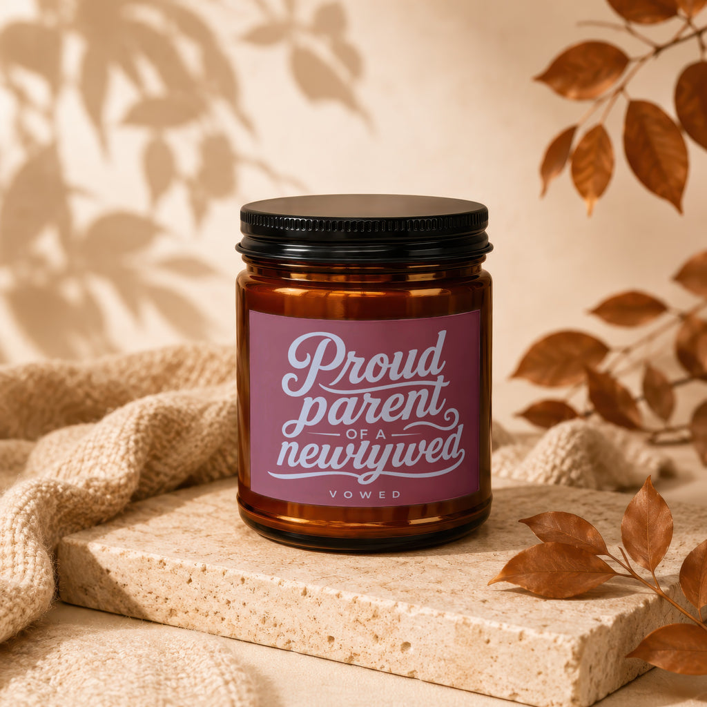 Amber candle with "Proud parent of a newlywed vowed" label on textured stone.