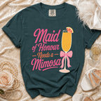 Dark teal t-shirt with pink text "Maid of Honour Needs a Mimosa" and a mimosa graphic.