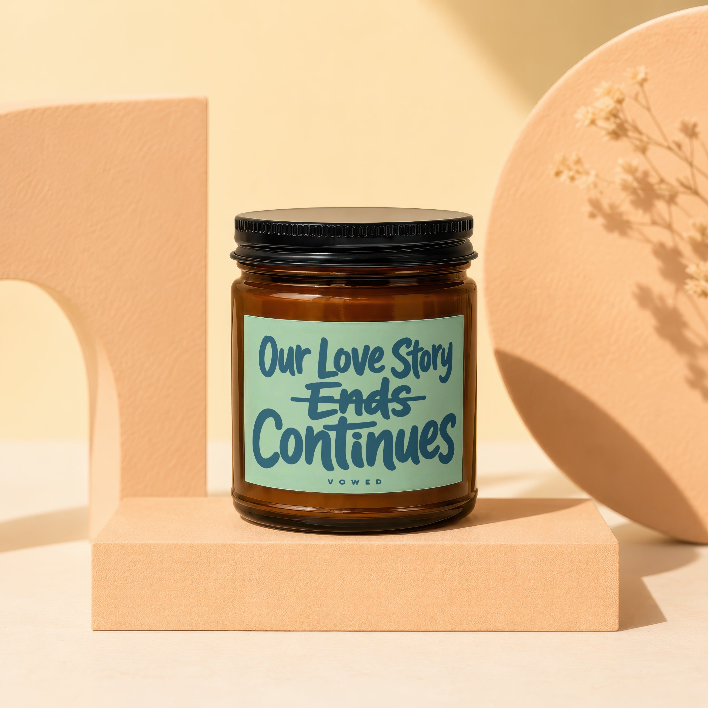 Amber candle with black lid labeled "Our Love Story Ends Continues vowed".