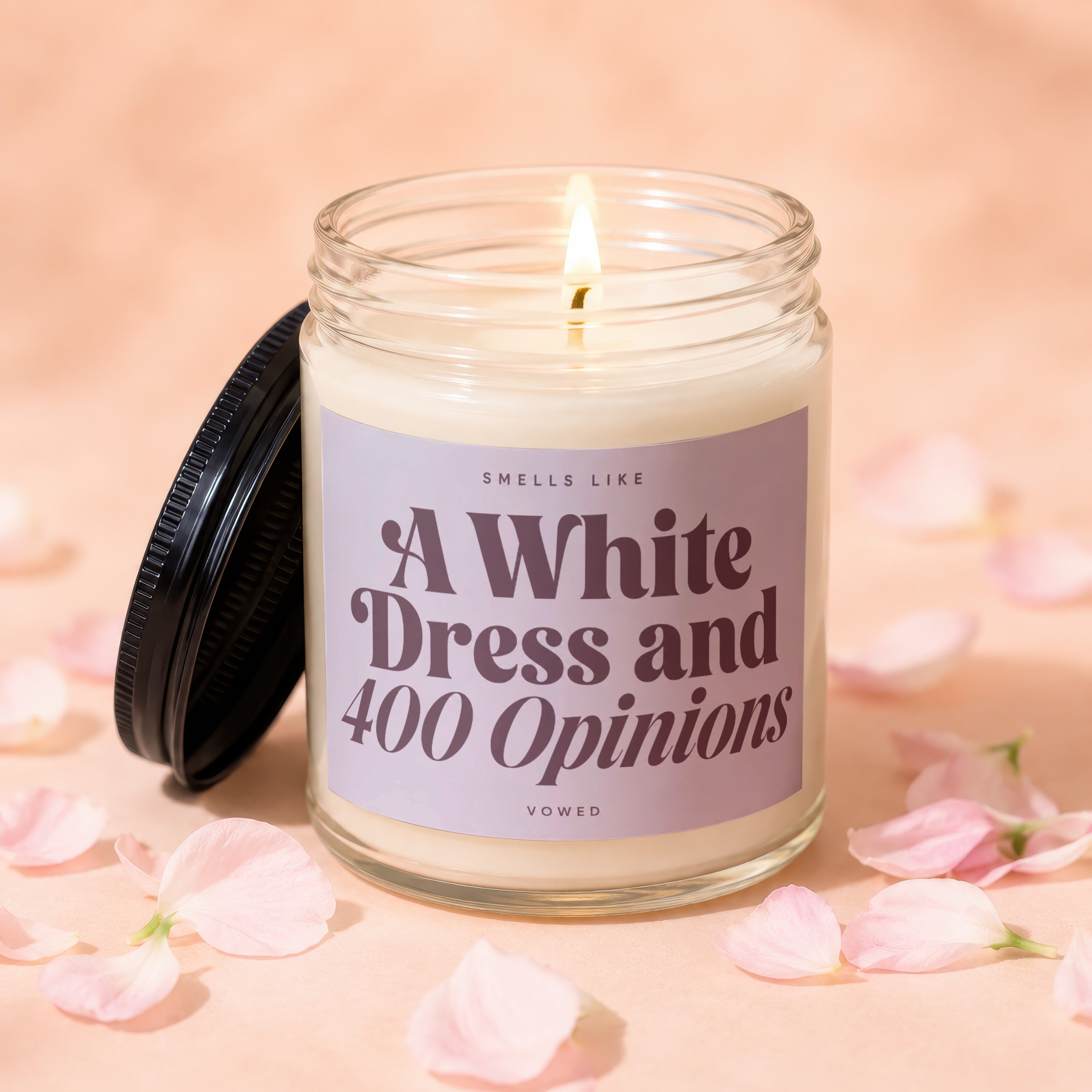 Candle with lit wick and text "Smells Like A White Dress and 400 Opinions".