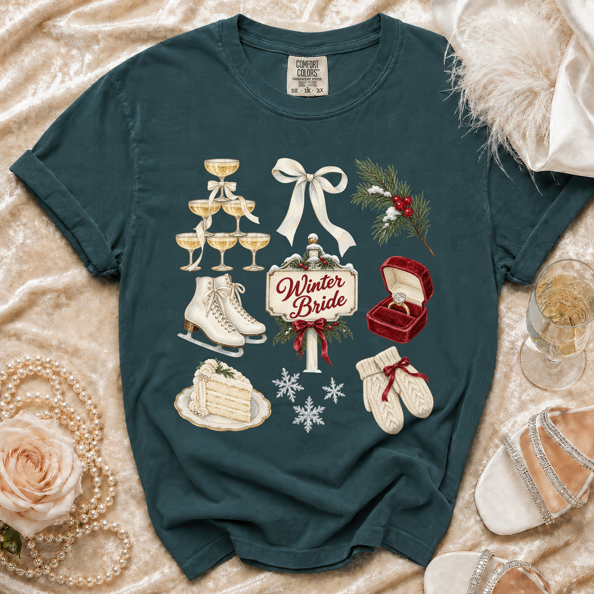 Teal t-shirt with "Winter Bride" graphic featuring champagne, ice skates, cake, and winter elements.