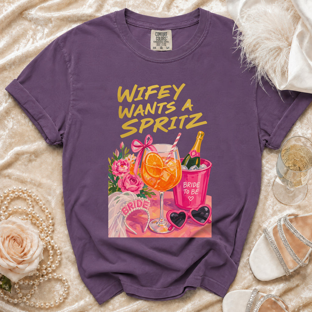 Purple t-shirt with "Wifey Wants A Spritz" graphic and bridal accessories.