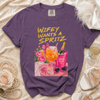Purple t-shirt with "Wifey Wants A Spritz" graphic and bridal accessories.