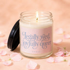 Lit candle in glass jar with pink label reading "Legally wed, joyfully queer VOWED".