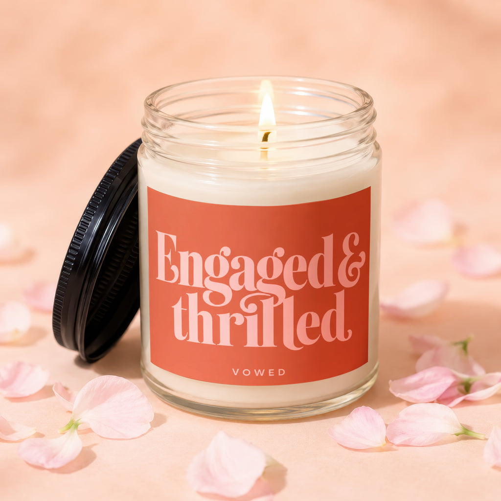 Candle with lit wick and 'Engaged & Thrilled' text on a pink background.