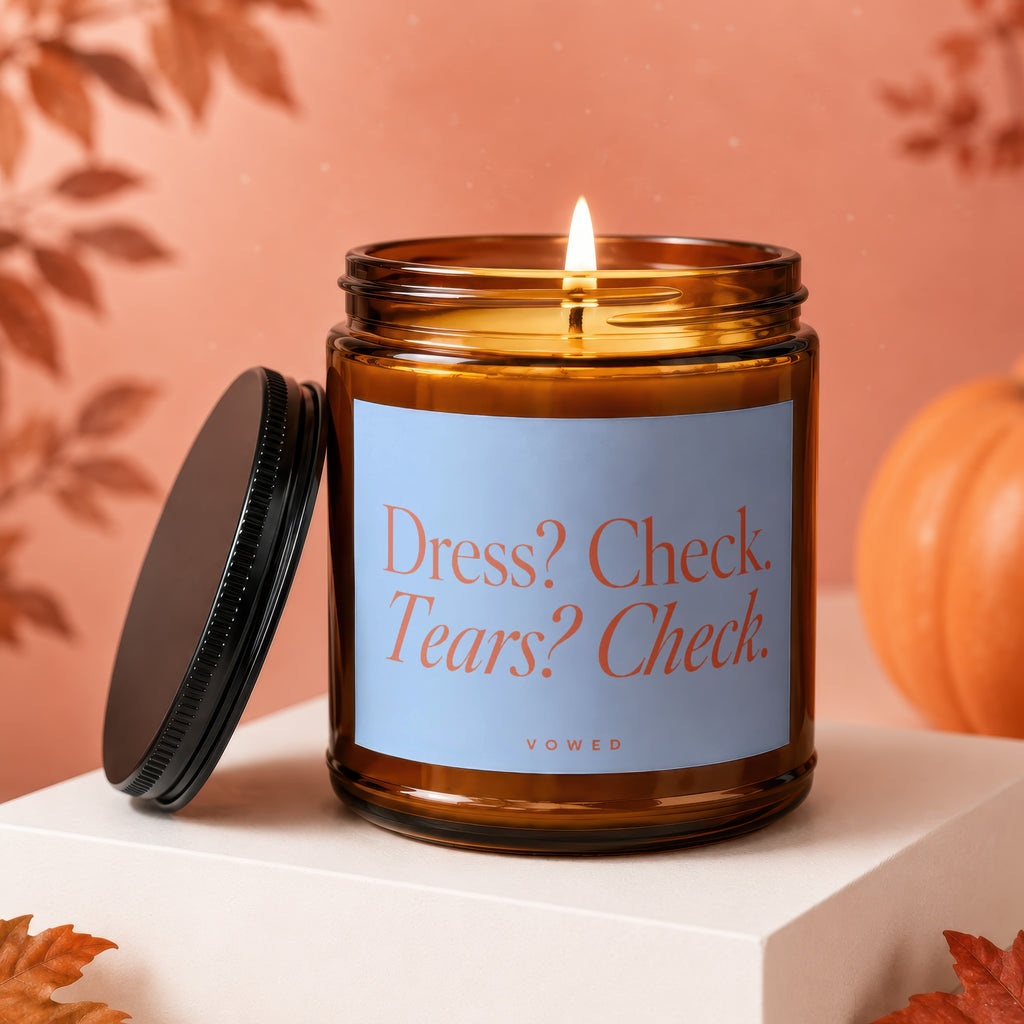 Amber candle with lid off reads "Dress? Check. Tears? Check." Vowed.