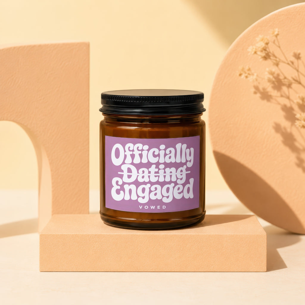 Amber candle with purple label reading "Officially Dating Engaged Vowed".