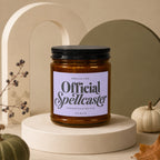 Brown glass candle labeled "Official Spellcaster" with decorative elements.