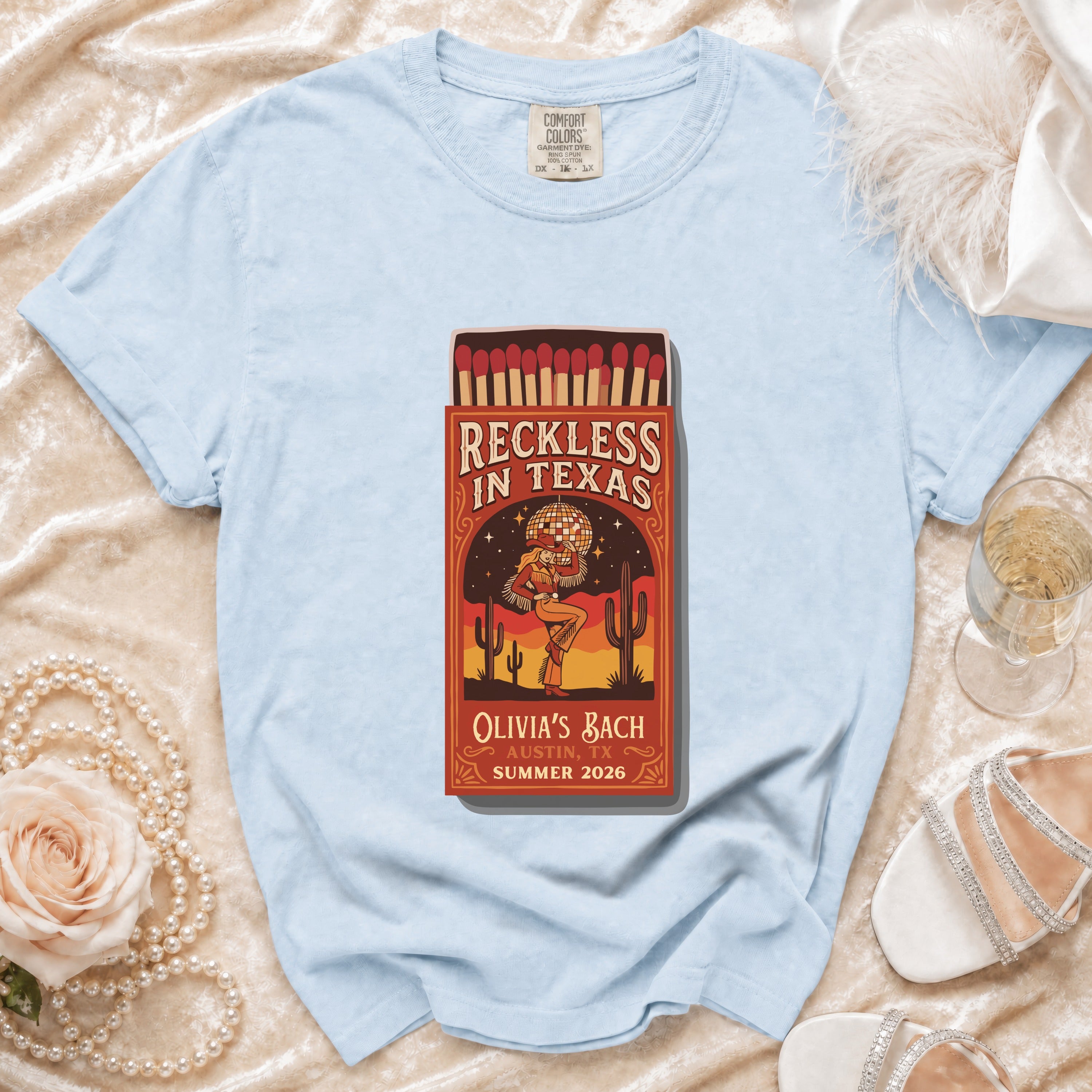 Light blue t-shirt with "Reckless in Texas" matchbox graphic.
