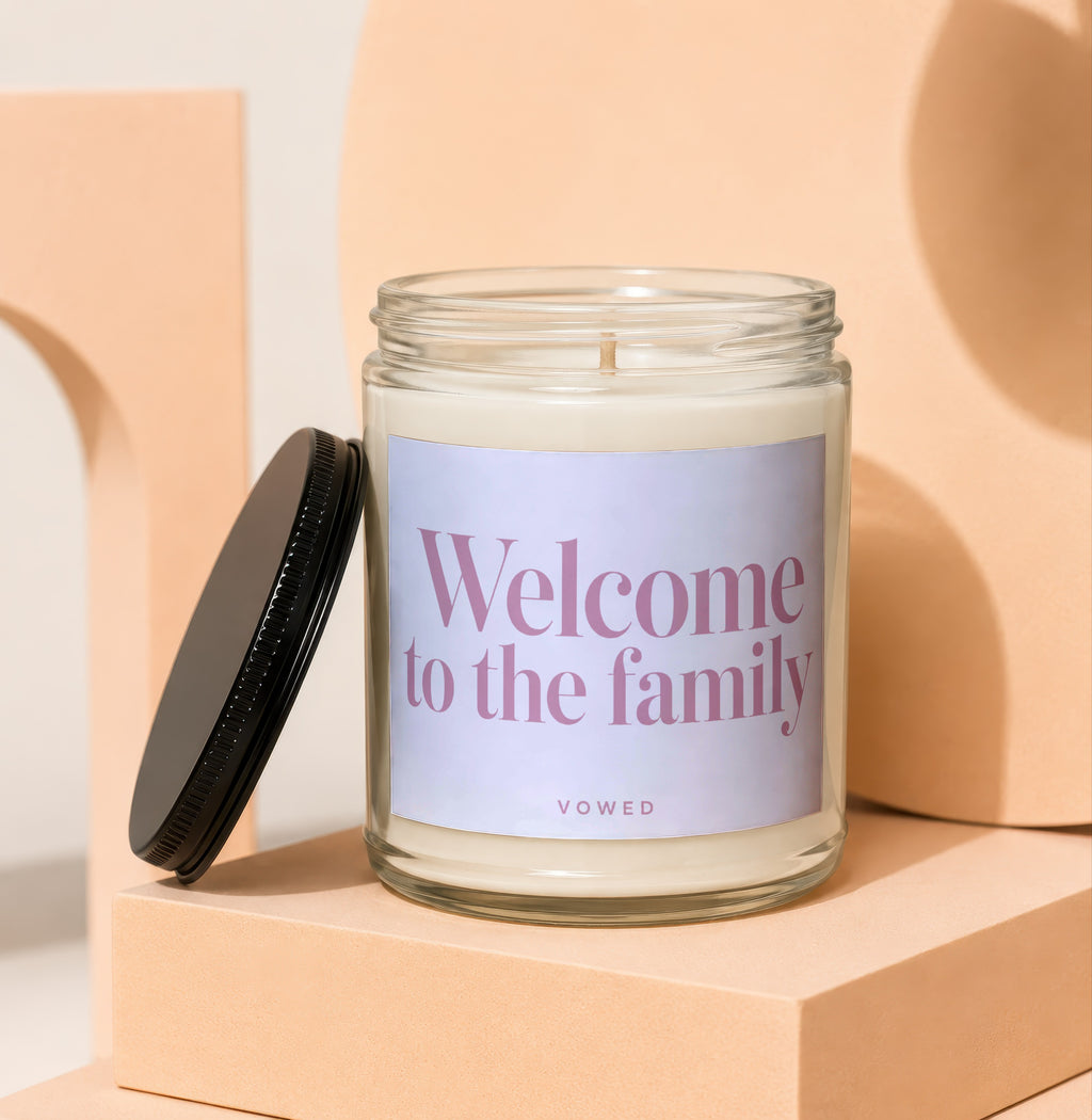 Glass candle with "Welcome to the family" text and "VOWED" logo.