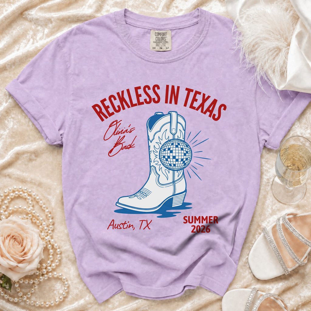 Purple t-shirt with "Reckless in Texas" and cowboy boot graphic.