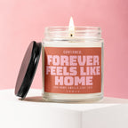Candle with label "CONFIRMED: FOREVER FEELS LIKE HOME AND HOME SMELLS LIKE THIS".