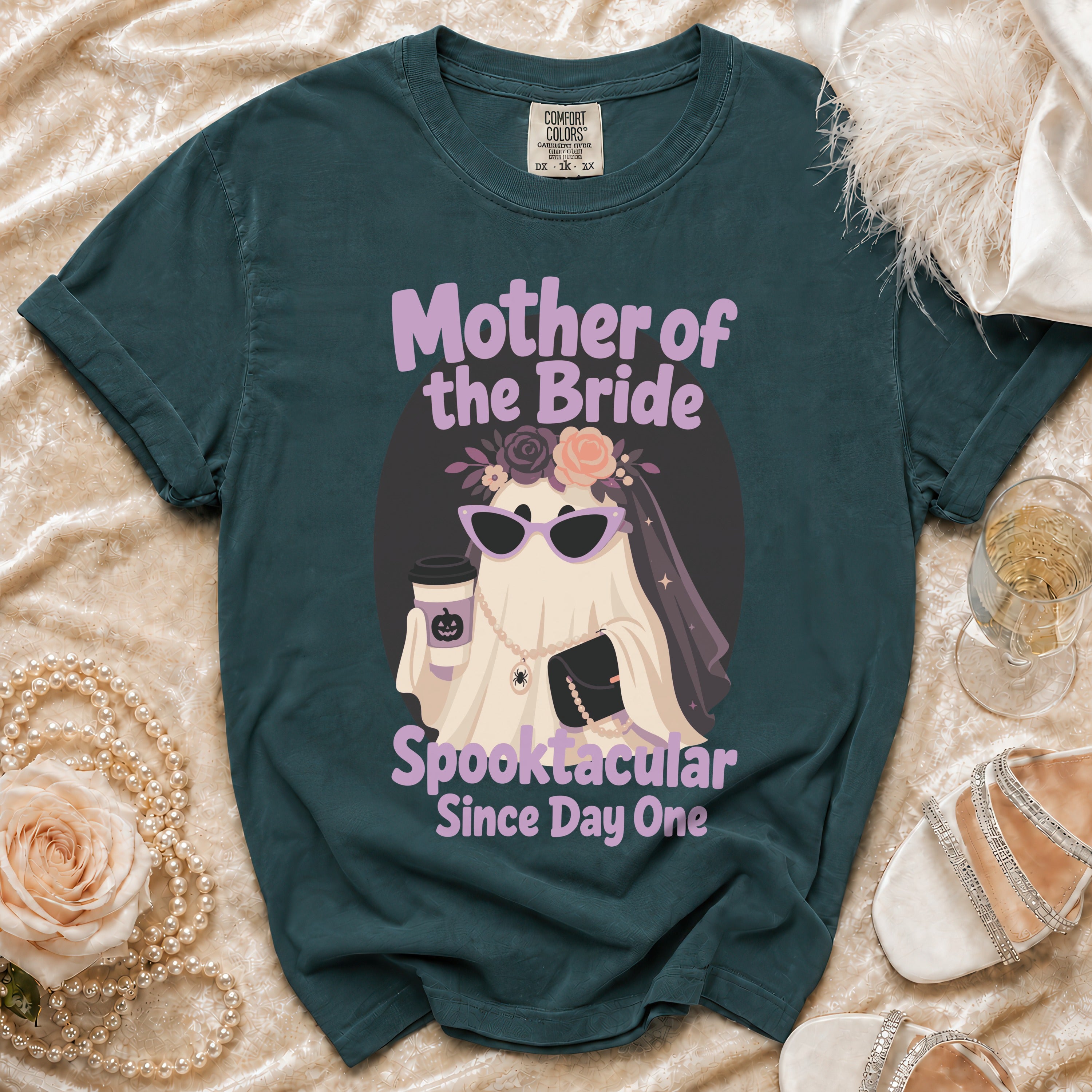 Dark teal t-shirt with a ghost graphic saying "Mother of the Bride Spooktacular Since Day One".