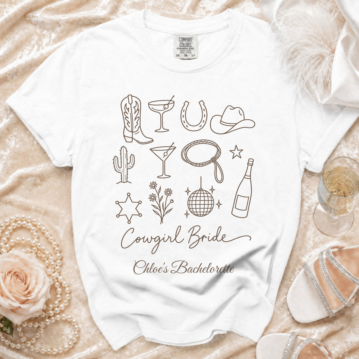 White t-shirt printed with brown outline icons and the text Cowgirl Bride Chloe's Bachelorette.