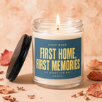 Lit candle in glass jar with blue label reading "Light When: First Home, First Memories".