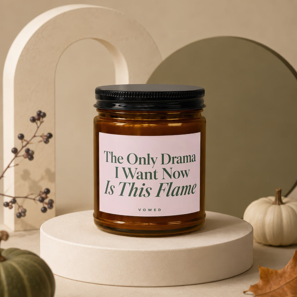 Amber candle in a jar with a black lid and pink label that reads "The Only Drama I Want Now Is This Flame."