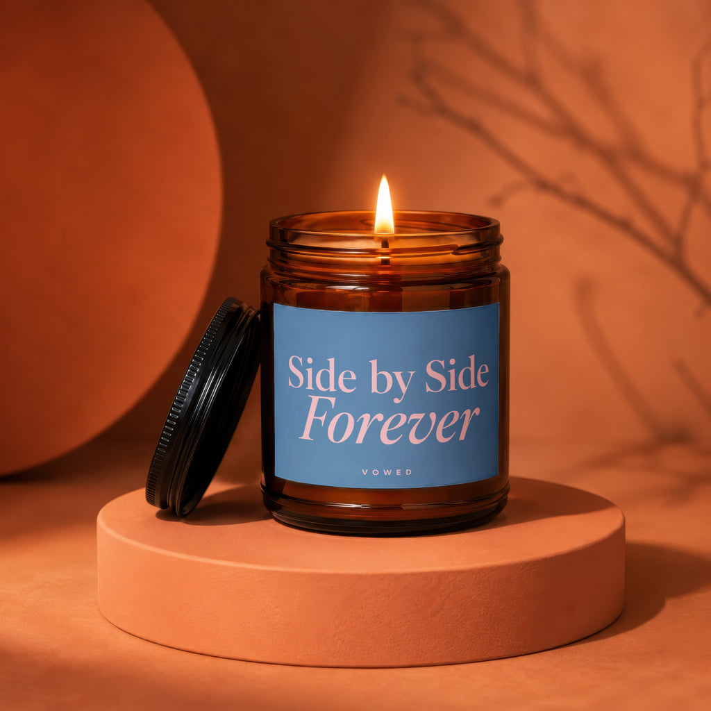 Amber glass candle with lid removed, features blue label with pink text "Side by Side Forever".