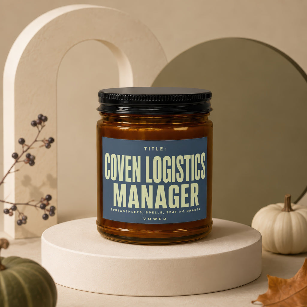 Glass jar candle with text "Coven Logistics Manager" and "Spreadsheets, Spells, Seating Charts".