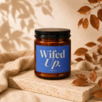 Brown candle with blue label reading "Wifed Up. Vowed."