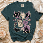 Teal t-shirt with Halloween-themed graphics including cats, ghost, and haunted house.