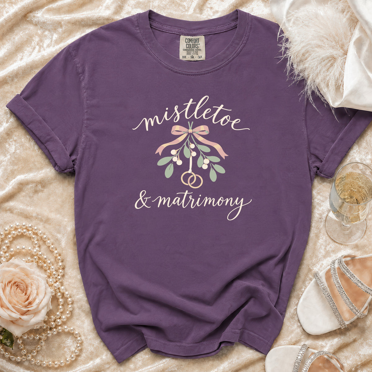 Purple t-shirt with "mistletoe & matrimony" text and mistletoe graphic.