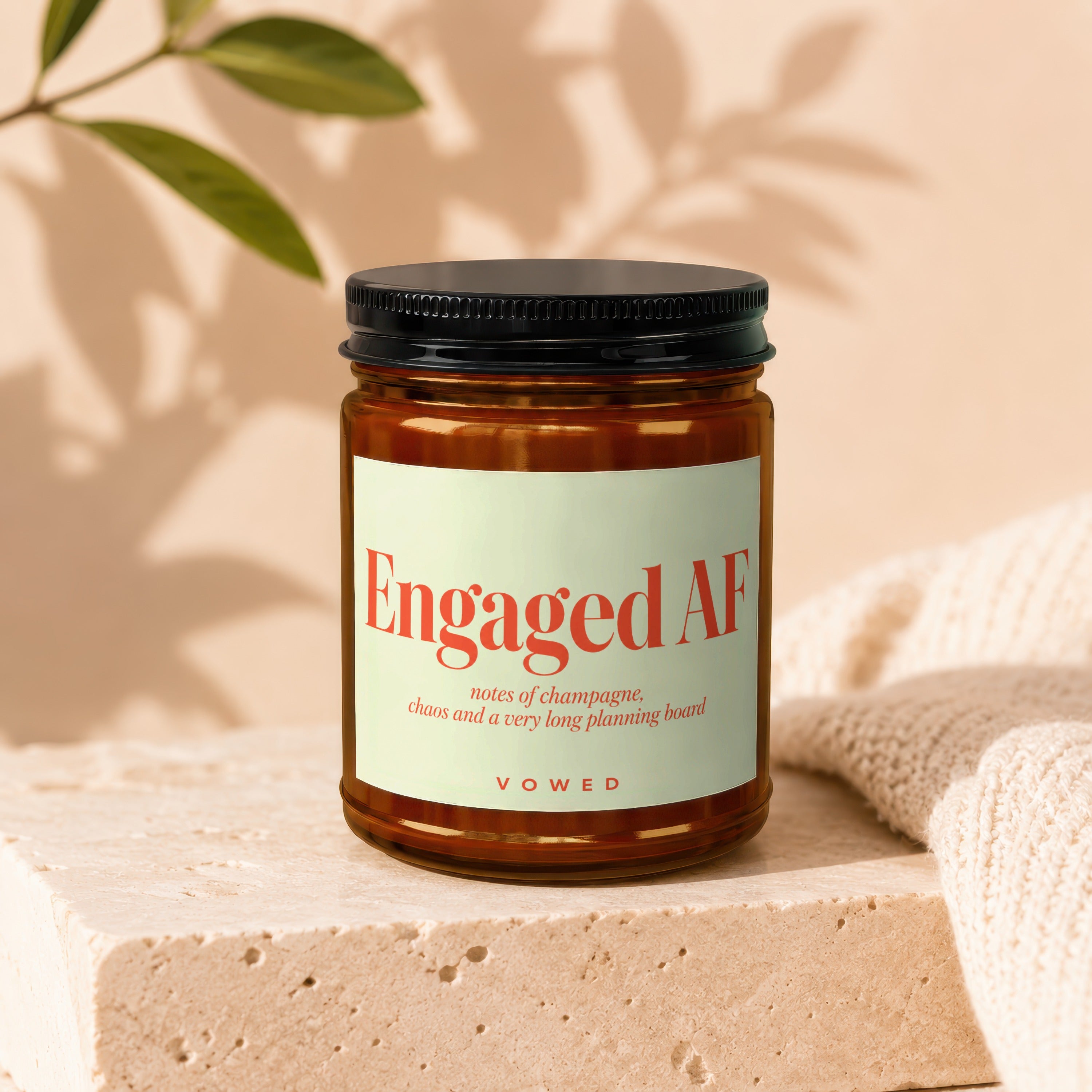 Amber jar candle with label reading "Engaged AF" and "VOWED".