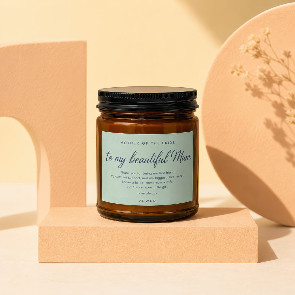 Amber jar candle with "MOTHER OF THE BRIDE" and a message, arranged elegantly.