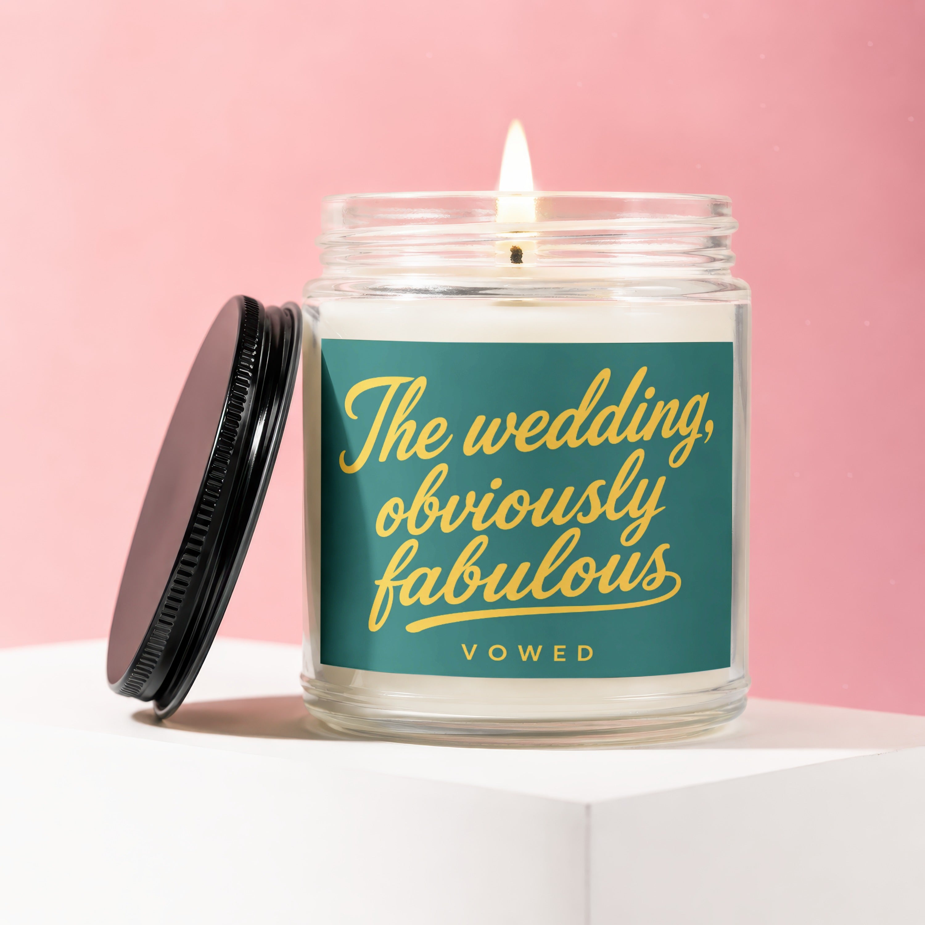 Candle with teal label reading "The wedding, obviously fabulous" in yellow script.