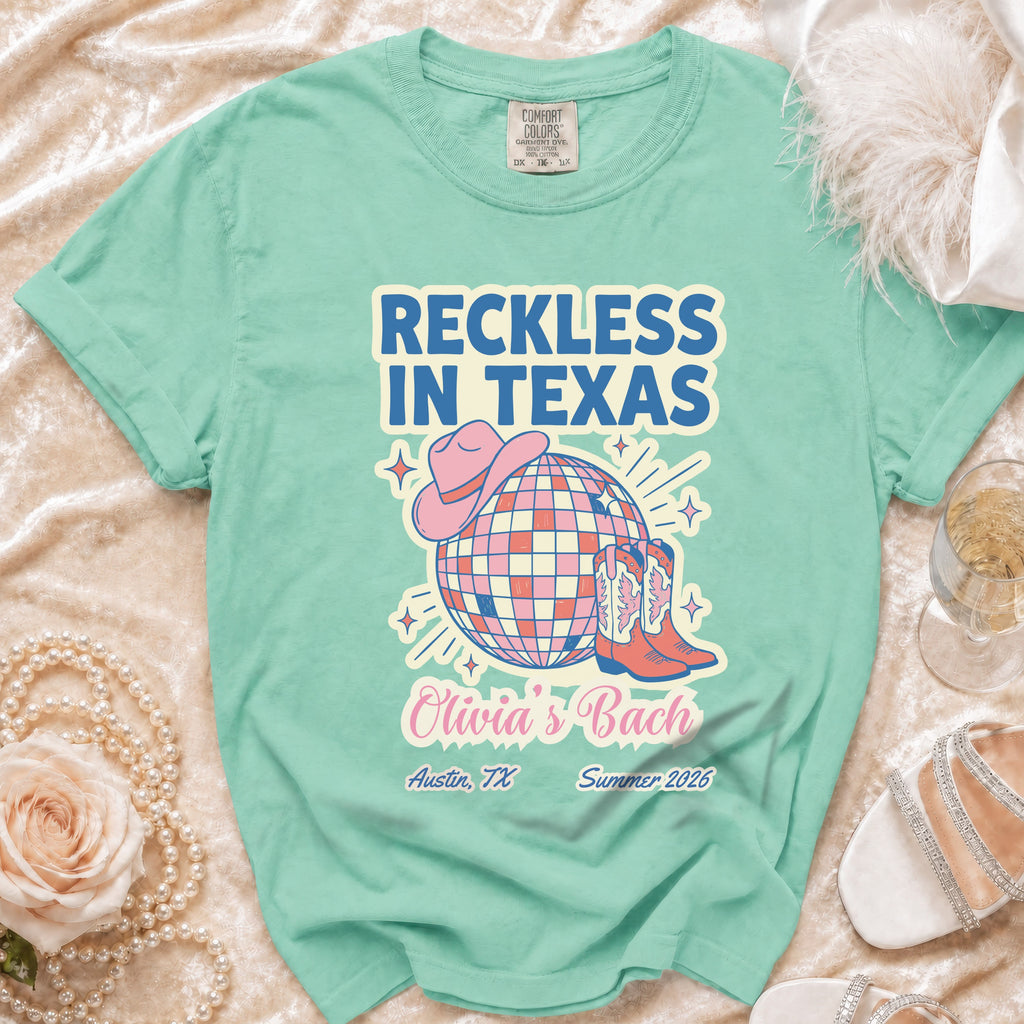 Teal t-shirt with "Reckless in Texas" and party graphics for Olivia's Bach in Austin.