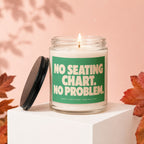 Candle with lit wick and green label reading "No Seating Chart. No Problem."